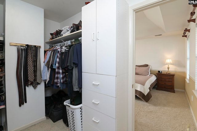 walk in closet featuring light colored carpet