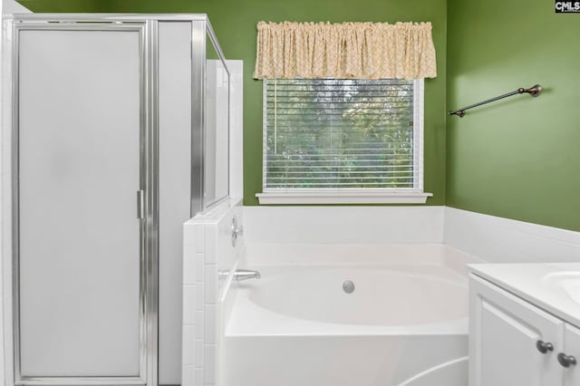 bathroom with vanity and independent shower and bath