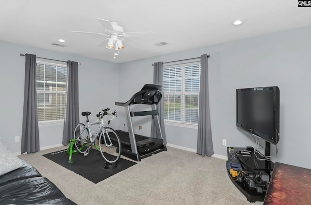 exercise room featuring light carpet and ceiling fan