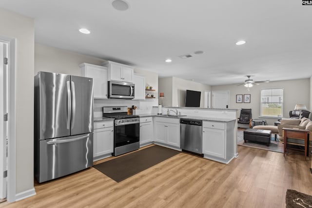 kitchen featuring white cabinets, ceiling fan, light wood-type flooring, kitchen peninsula, and stainless steel appliances