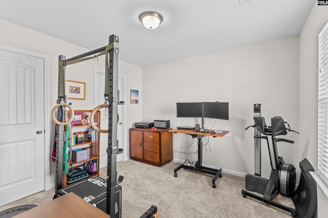 workout room featuring light carpet