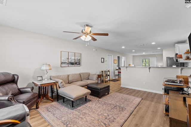 living room with ceiling fan and light wood-type flooring