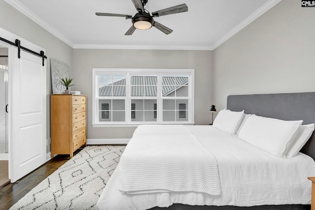 bedroom with a barn door, ceiling fan, dark wood-type flooring, and ornamental molding