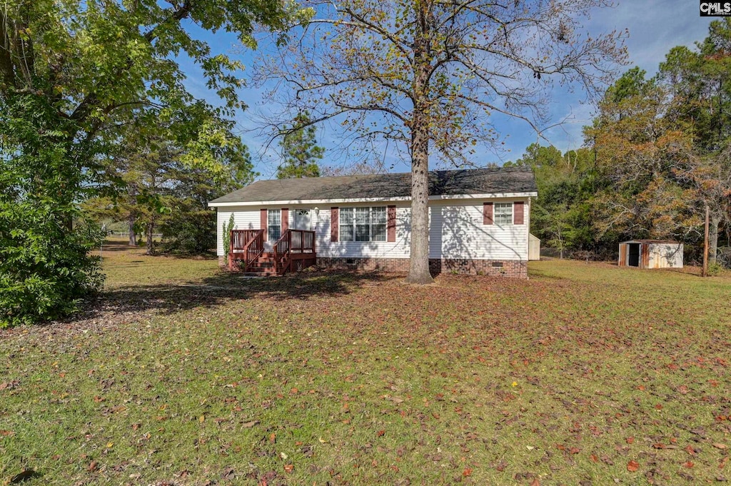 view of front facade featuring a front yard and a storage unit