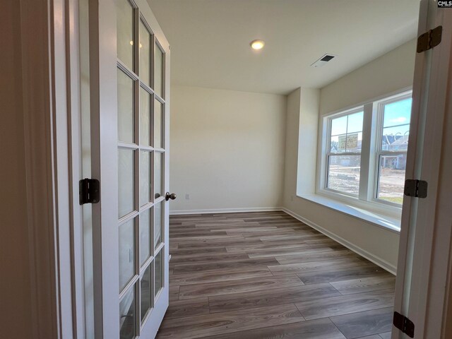 unfurnished room featuring hardwood / wood-style floors and french doors