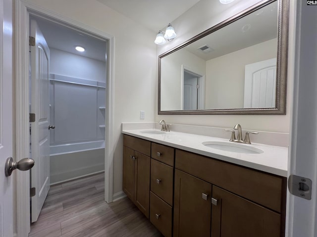 bathroom with vanity, hardwood / wood-style flooring, and  shower combination