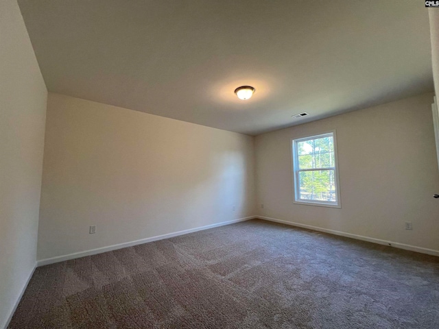 spare room with dark colored carpet