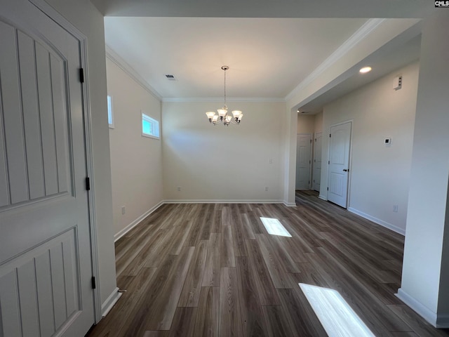 unfurnished dining area with crown molding, dark hardwood / wood-style flooring, and a chandelier