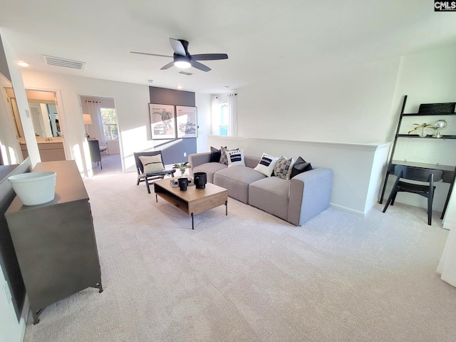 carpeted living room with ceiling fan