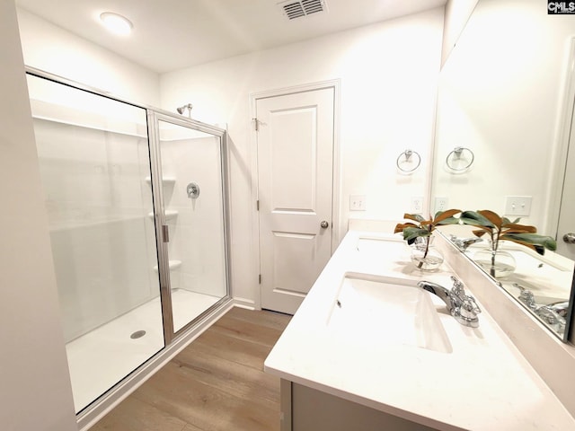 bathroom featuring hardwood / wood-style floors, vanity, and a shower with door