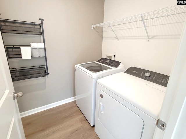 laundry room featuring washer and dryer and light hardwood / wood-style flooring