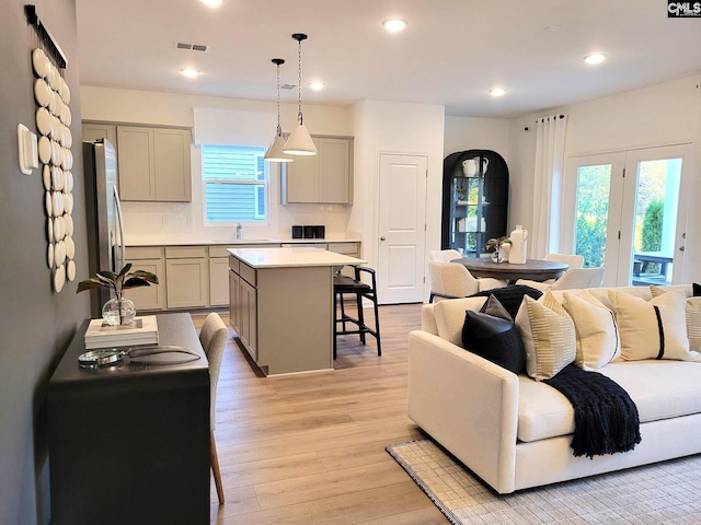 living room with light wood-type flooring, plenty of natural light, and sink