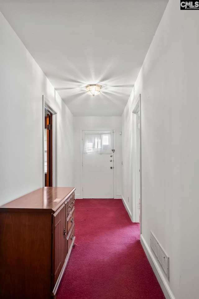 foyer featuring dark colored carpet