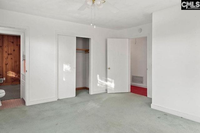 unfurnished bedroom featuring ceiling fan, light colored carpet, connected bathroom, and a closet