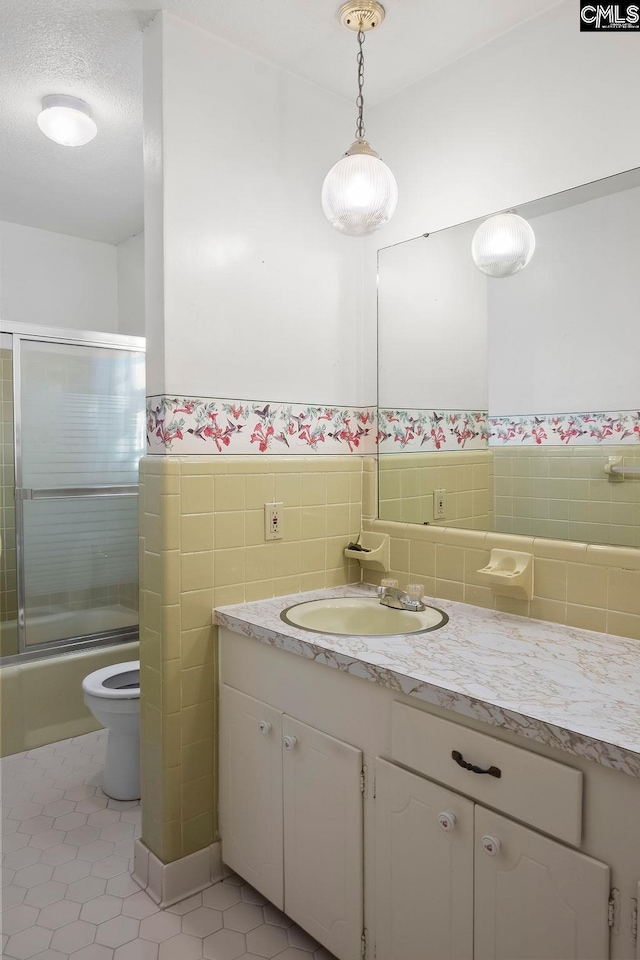 full bathroom featuring enclosed tub / shower combo, tile patterned floors, vanity, and toilet