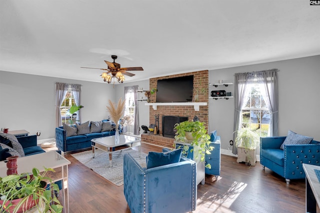 living room featuring a wealth of natural light, dark hardwood / wood-style floors, a brick fireplace, and ceiling fan