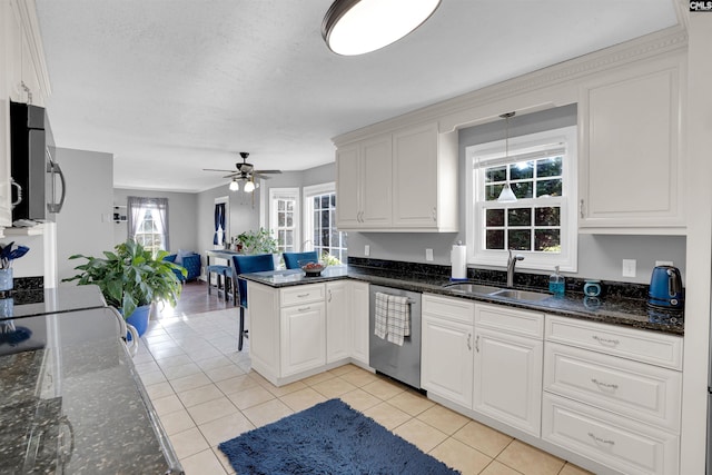 kitchen featuring white cabinets, sink, stainless steel dishwasher, ceiling fan, and light tile patterned floors