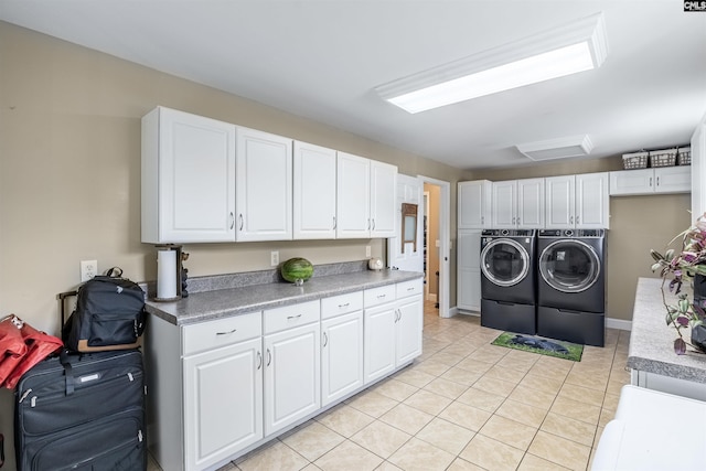 washroom featuring cabinets, light tile patterned floors, and washing machine and clothes dryer