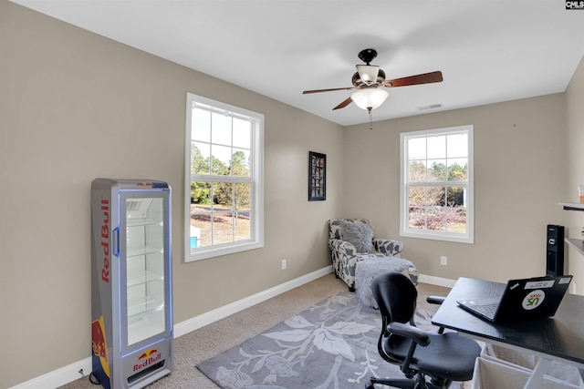 office space with light carpet, a wealth of natural light, and ceiling fan