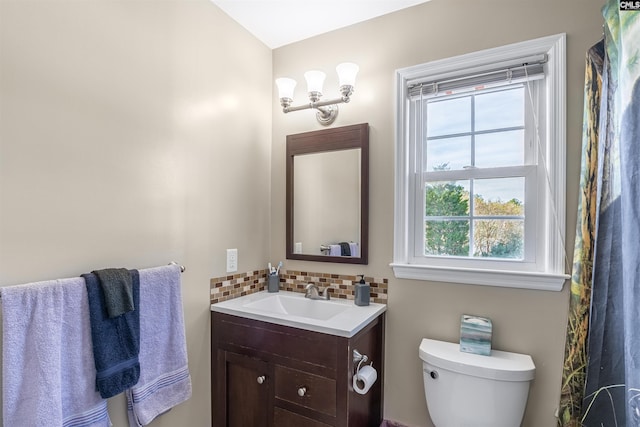 bathroom featuring decorative backsplash, vanity, and toilet