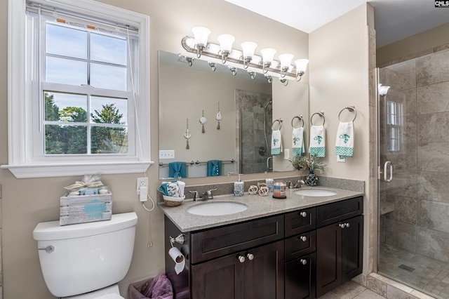 bathroom featuring vanity, toilet, and a shower with door