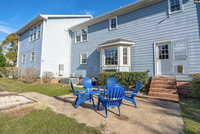 rear view of house with central air condition unit, a yard, and a patio