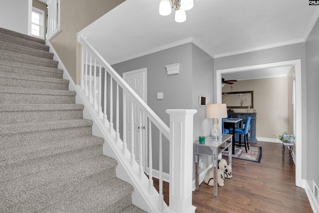 staircase featuring wood-type flooring and ornamental molding