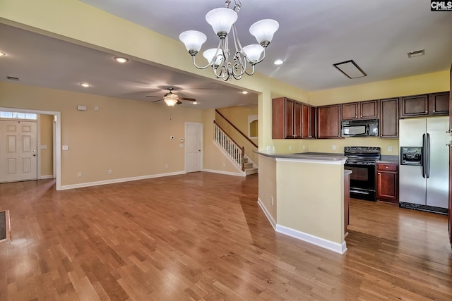 kitchen featuring black appliances, decorative light fixtures, light hardwood / wood-style floors, and ceiling fan with notable chandelier