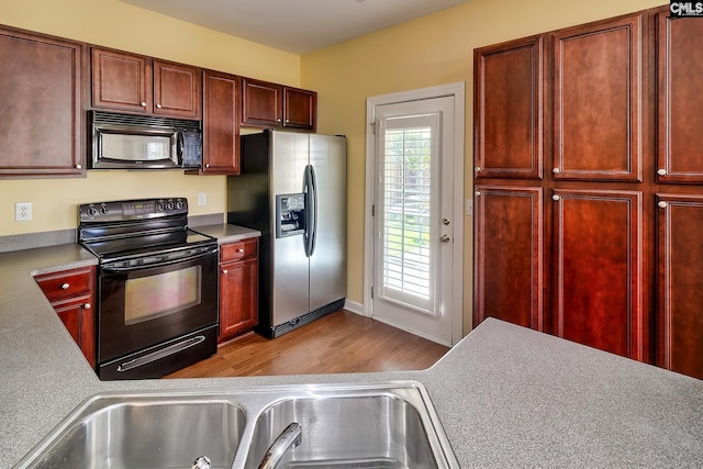 kitchen featuring light wood-type flooring and black appliances