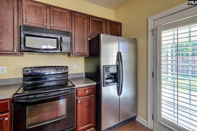 kitchen featuring dark wood-type flooring and black appliances