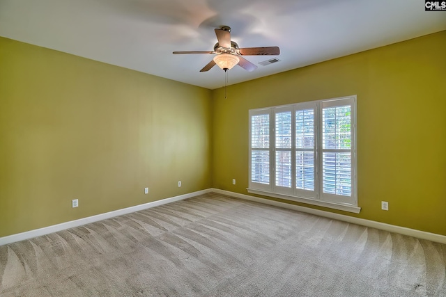 spare room featuring light carpet and ceiling fan