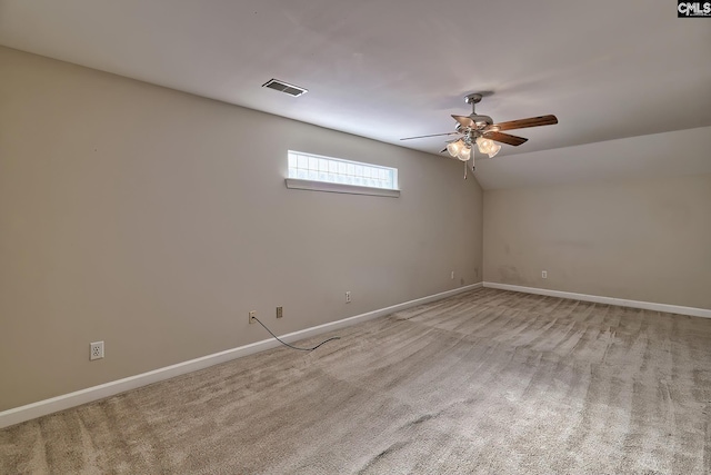 empty room featuring ceiling fan, lofted ceiling, and light carpet