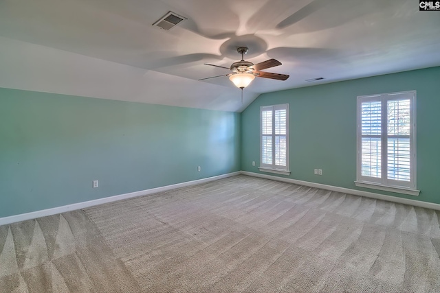 empty room with ceiling fan, light colored carpet, and lofted ceiling