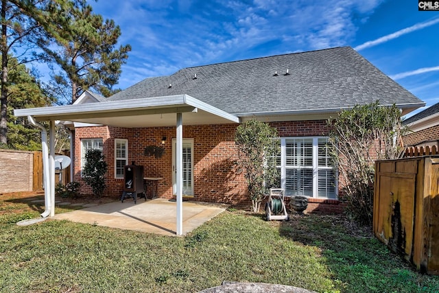 rear view of house with a lawn and a patio area