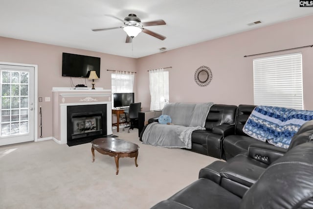 living room with carpet flooring, a wealth of natural light, and ceiling fan