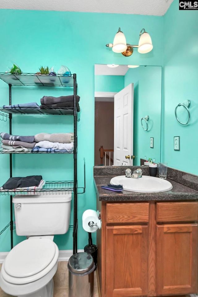 bathroom featuring tile patterned floors, vanity, and toilet