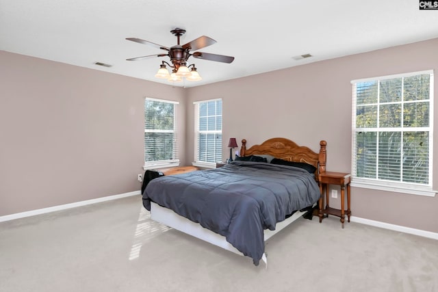 carpeted bedroom featuring ceiling fan and multiple windows