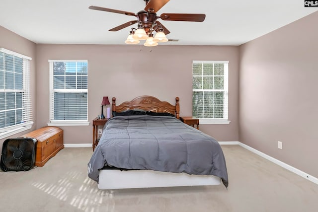 carpeted bedroom featuring multiple windows and ceiling fan