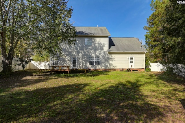 rear view of house featuring a deck and a lawn