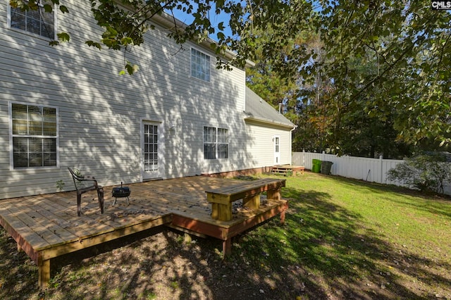 rear view of property with a deck and a lawn