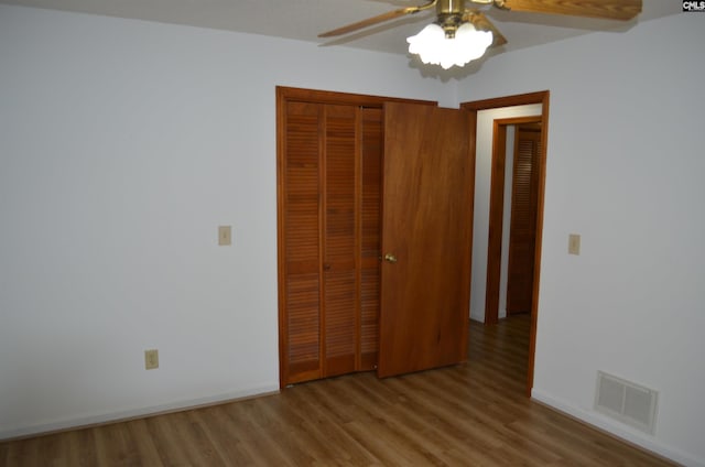 unfurnished bedroom featuring a closet, light hardwood / wood-style floors, and ceiling fan