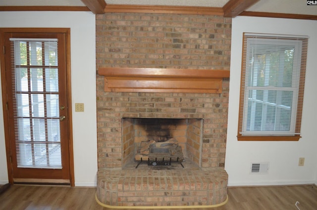 room details featuring hardwood / wood-style flooring, a brick fireplace, and ornamental molding