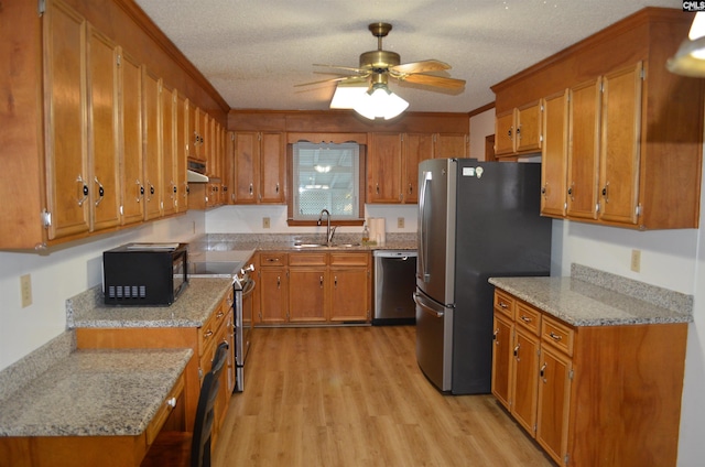 kitchen with sink, ceiling fan, light wood-type flooring, a textured ceiling, and appliances with stainless steel finishes