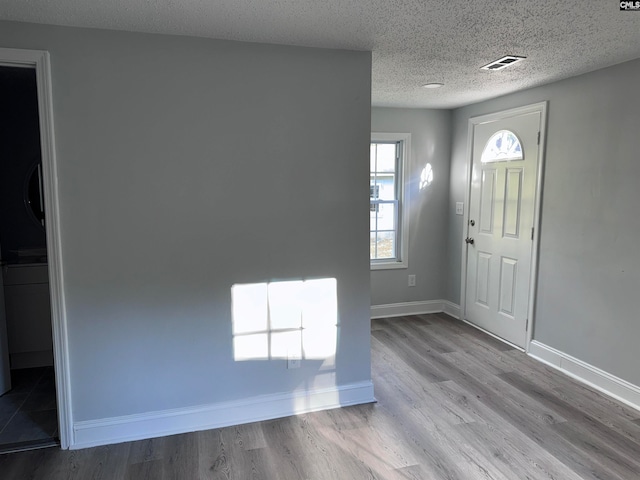 entrance foyer featuring light wood-type flooring and a textured ceiling