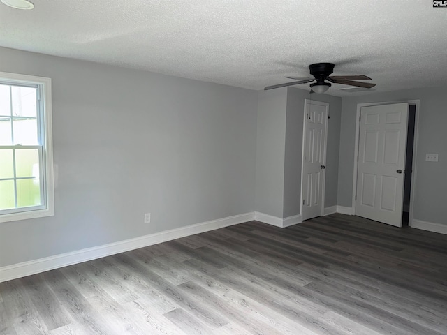 empty room with hardwood / wood-style floors, ceiling fan, and a textured ceiling