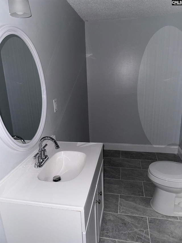 bathroom featuring vanity, toilet, and a textured ceiling