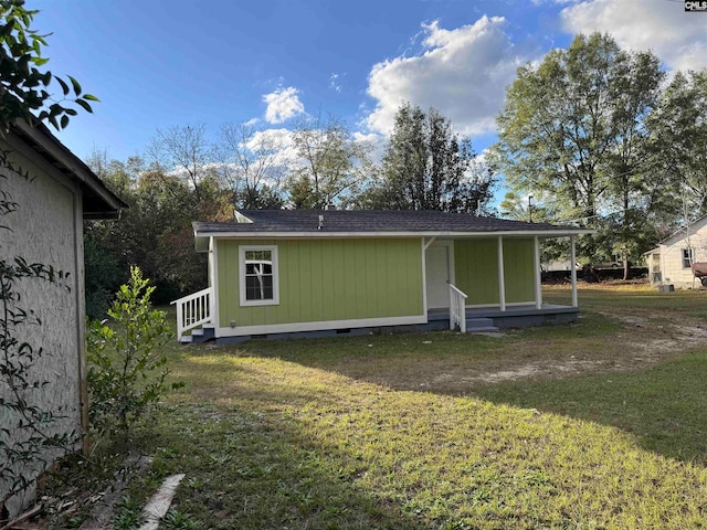 rear view of property featuring a lawn