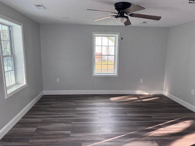 spare room with a textured ceiling, ceiling fan, and dark hardwood / wood-style floors