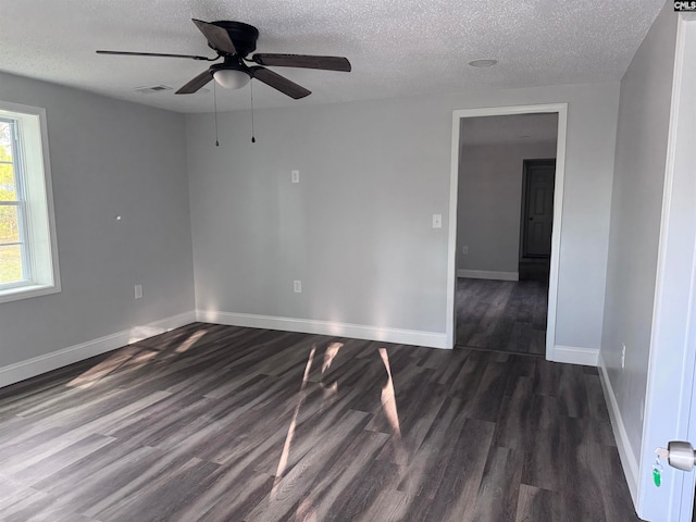 unfurnished room with ceiling fan, dark hardwood / wood-style flooring, and a textured ceiling