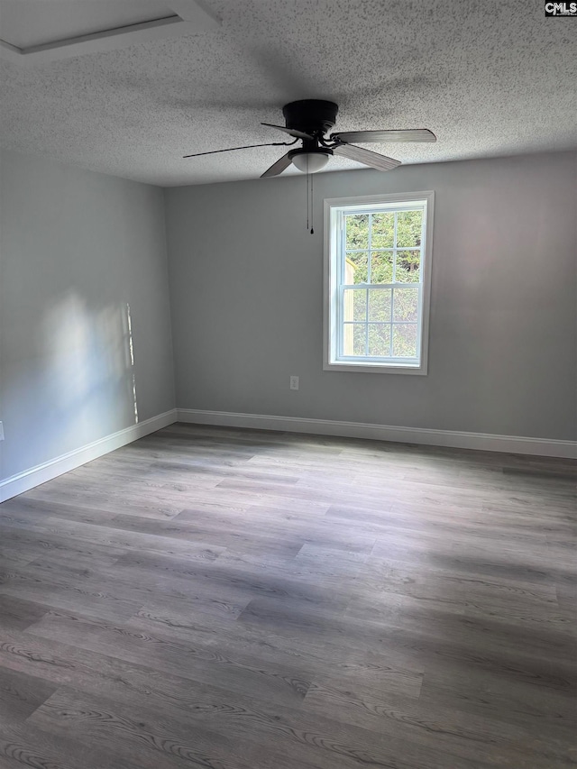 spare room with hardwood / wood-style floors, a textured ceiling, and ceiling fan